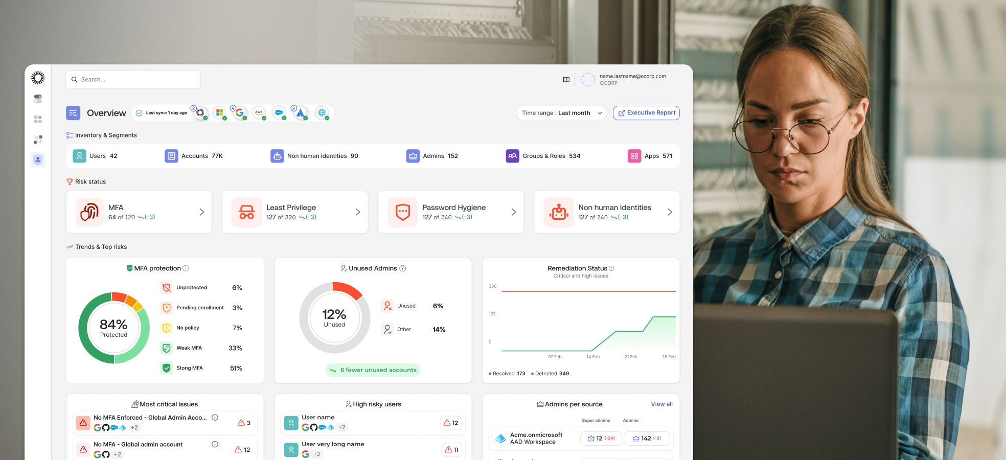 A security professional working on a laptop that displays the Okta Identity Security Posture Management dashboard for risk analysis.