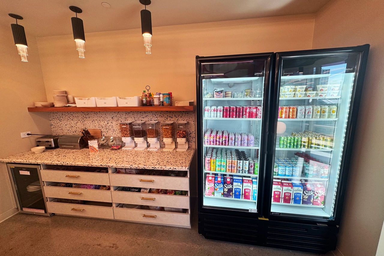 A modern snack bar featuring a countertop with cereal dispensers and packaged snacks.